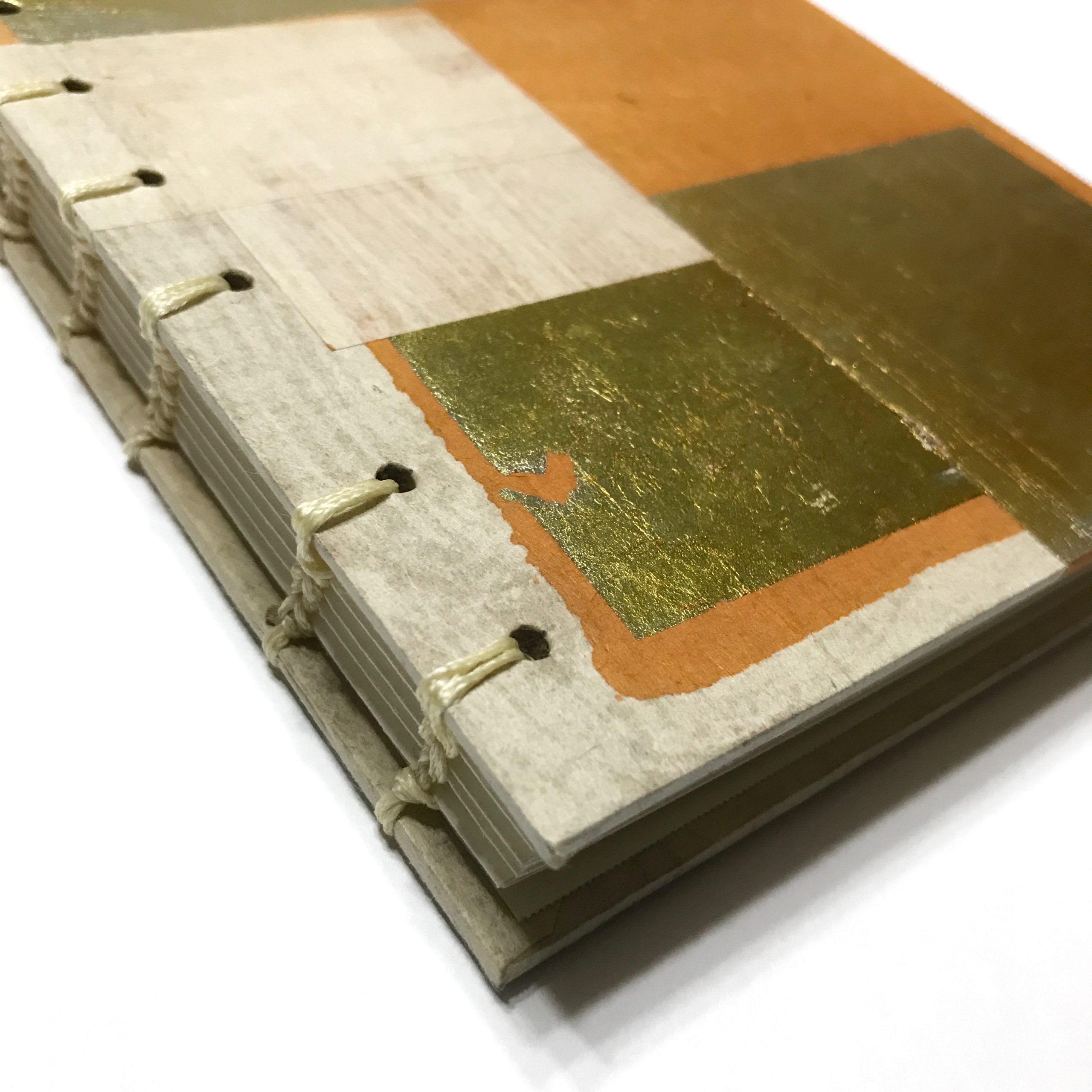 Closeup of cover of sketchbook with gold leaf and orange design