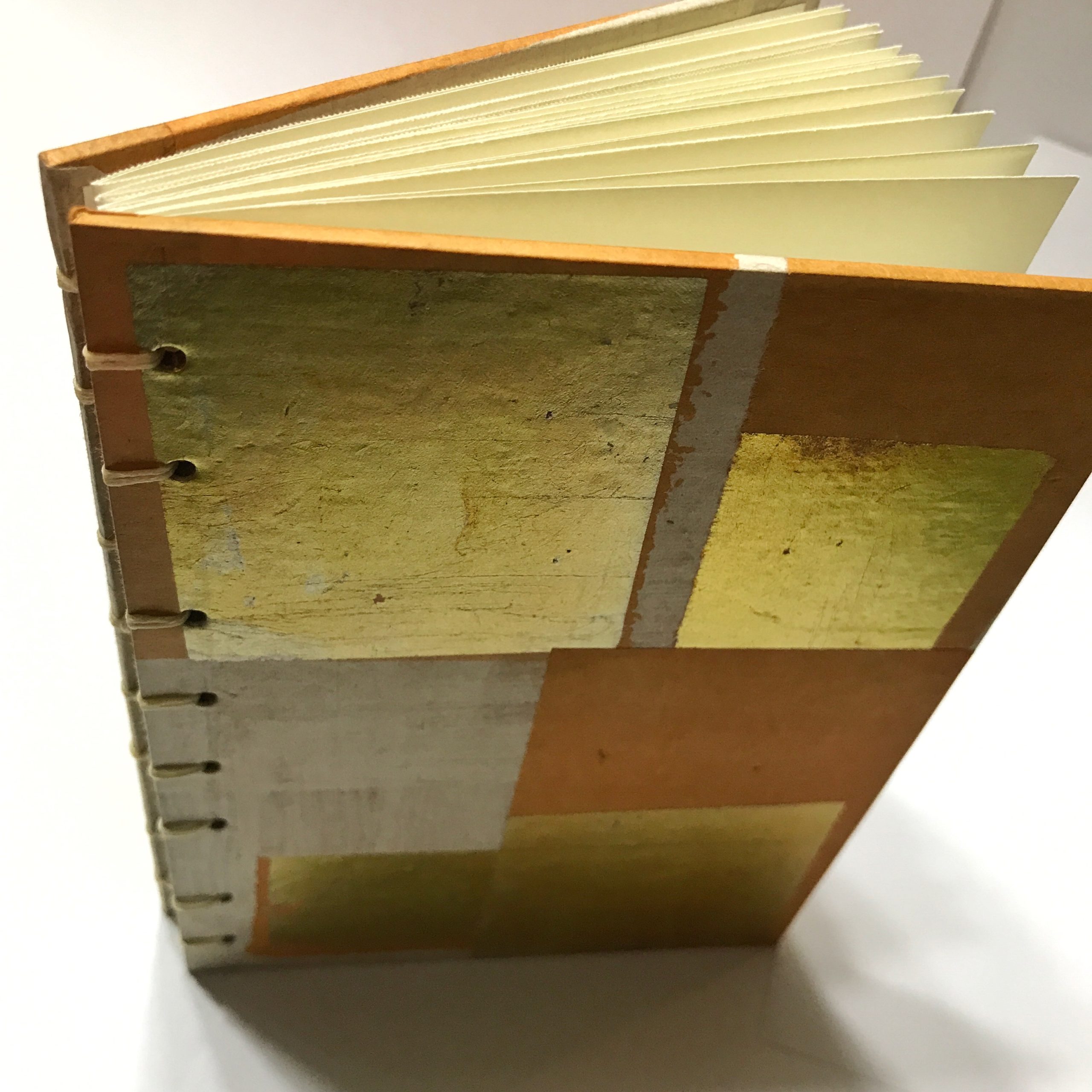 Top view of sketchbook with gold leaf and orange design